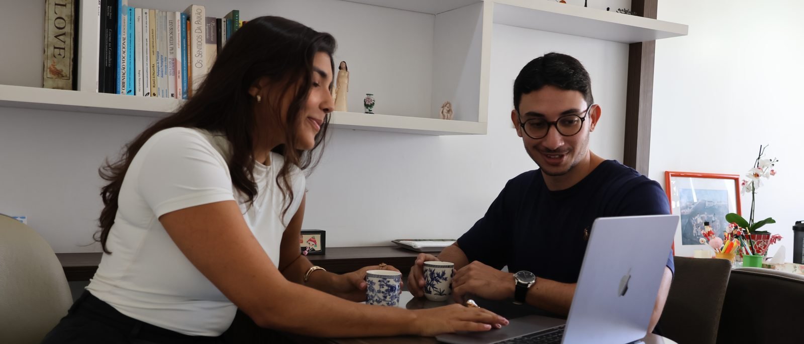 Luiza e Gustavo conversando à mesa de um dos consultórios da Benvivere